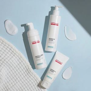 Drie verzorgingsproducten van Cell Fusion C uit de BARRIEDERM-lijn op een lichtblauwe ondergrond met textuur en productresten.