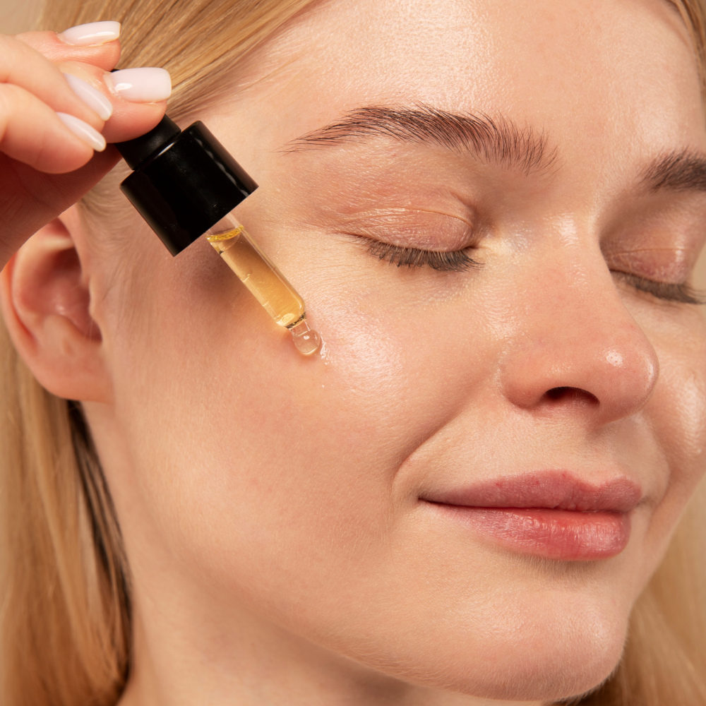 Vrouw brengt serum aan op haar wang met een pipet.