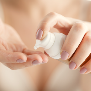 Vrouw brengt toner aan op hand vanuit een pompflacon.