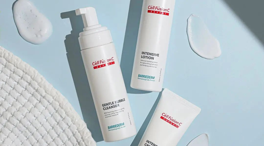 Drie verzorgingsproducten van Cell Fusion C uit de BARRIEDERM-lijn op een lichtblauwe ondergrond met textuur en productresten.